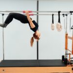 일상 속에서 필라테스, 건강한 몸과 마음을 위한 새 트렌드 a woman doing a handstand on a pivot machine