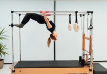 일상 속에서 필라테스, 건강한 몸과 마음을 위한 새 트렌드 a woman doing a handstand on a pivot machine