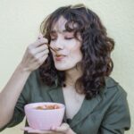 바쁜 일상 속 ‘마음 챙김 식사’, 건강과 만족 동시에 챙긴다 a woman holding a pink bowl of food