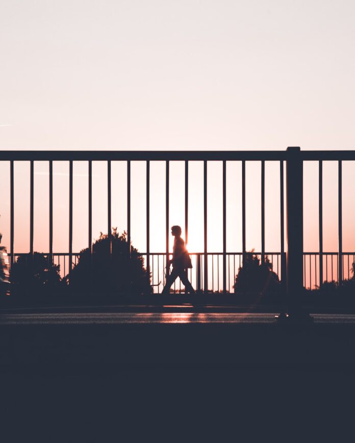 Photo by Kasper Rasmussen silhouette of person walking on roadside during sunset