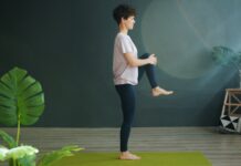 근육 건강, 집에서도 쉽게 챙긴다…일상 속 실천법 인기 Woman practicing yoga on a green mat indoors.