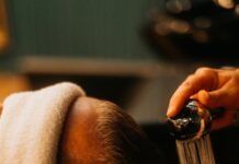 “두피부터 건강하게, 요즘 뜨는 헤어케어 루틴” a man getting his hair washed in a sink