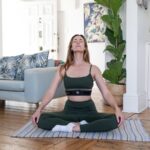 “마음 챙김 명상이 일상 속 스트레스를 누그러뜨린다…쉽게 시작하는 실천법은?” a woman sitting on a yoga mat in a living room