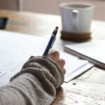 일상에서 실천하는 웰니스 문화, 작은 변화가 건강을 부른다 person writing on brown wooden table near white ceramic mug