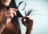 최신 ‘헤어 헬스’ 트렌드, 집에서 실천하는 건강한 머릿결 관리법 Woman examining split ends of hair with magnifying glass