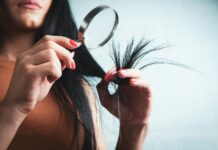 최신 ‘헤어 헬스’ 트렌드, 집에서 실천하는 건강한 머릿결 관리법 Woman examining split ends of hair with magnifying glass