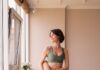 일상 속 필라테스, 내 몸에 맞는 맞춤 건강법으로 뜬다 a woman in a green sports bra top and leggings holding a yoga mat