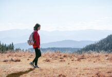 걷기 열풍, 일상 속 건강 지키는 작은 변화가 만든다 a man with a backpack walking across a dry grass covered field