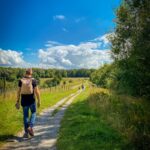 건강을 위한 ‘마음챙김 산책’…도심서 실천하는 휴식의 새로운 트렌드 man in brown t-shirt and blue denim shorts walking on pathway between green grass field